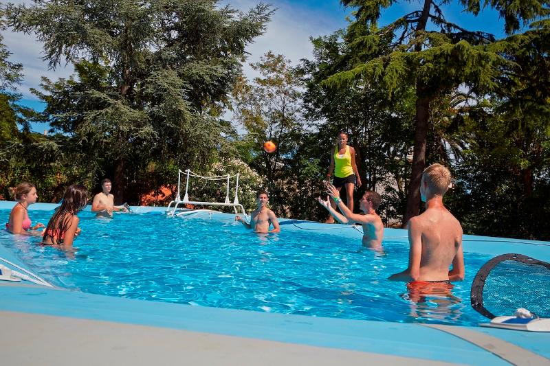 Al soggiorno linguistico francese i ragazzi stanno giocando a pallavolo in piscina
