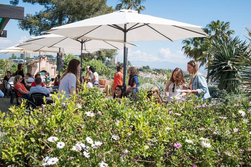Al soggiorno linguistico francese c'è una terrazza esterna con fiori e ombrelloni 