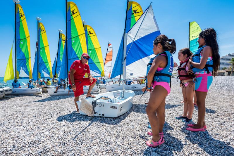 Al soggiorno linguistico francese tre bambine stanno ascoltando le istruzioni per andare sulla barca a vela