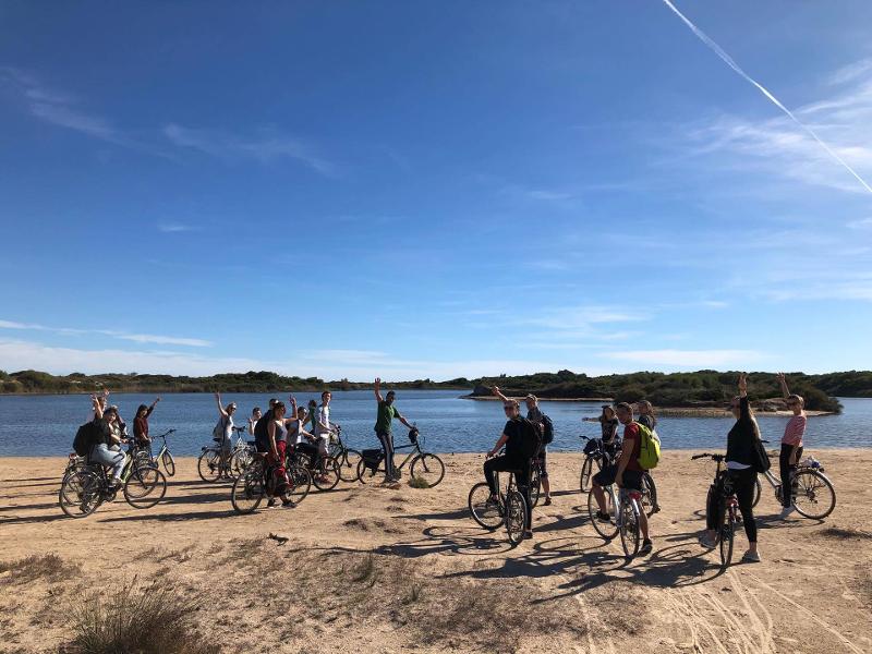 I ragazzi del soggiorno linguistico spagnolo si fermano con le biciclette sulla spiaggia per una breve pausa