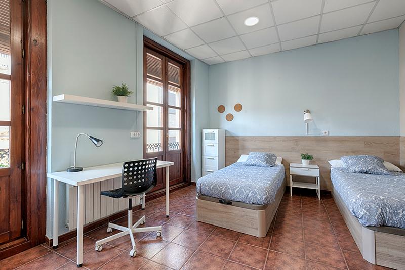Camera da letto doppia con letti separati e ampie finestre al soggiorno linguistico spagnolo