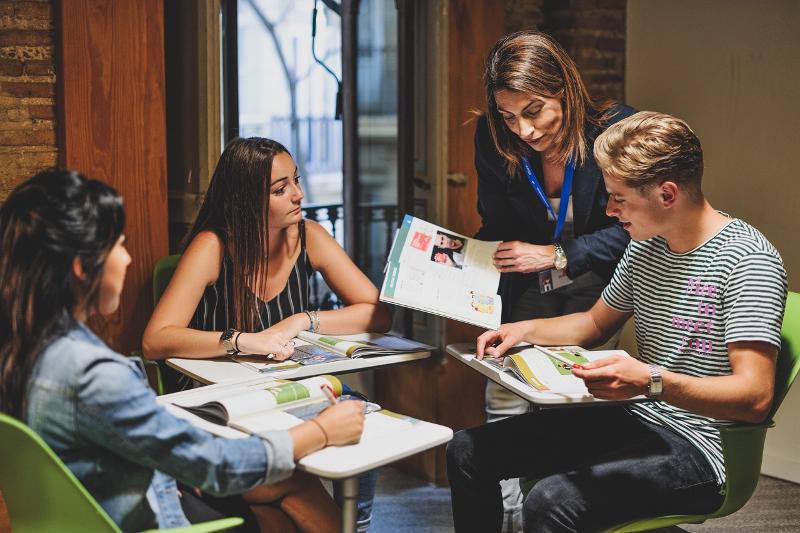 I partecipanti del soggiorno linguistico spagnolo fanno domande all'insegnante della scuola