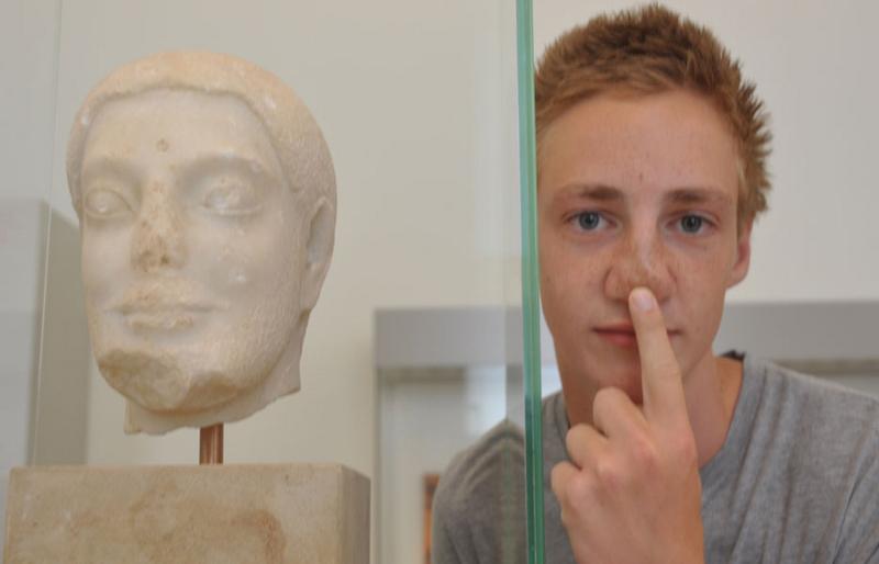 Un ragazzo del soggiorno linguistico tedesco imita una statua di un museo