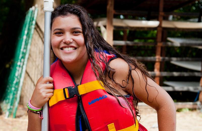 Una ragazza del soggiorno linguistico tedesco impugna un remo e indossa un giubbotto di salvataggio