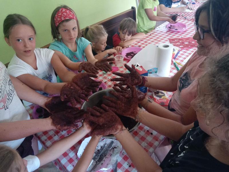 Ai campi estivi in fattoria un gruppo di bambine impastano