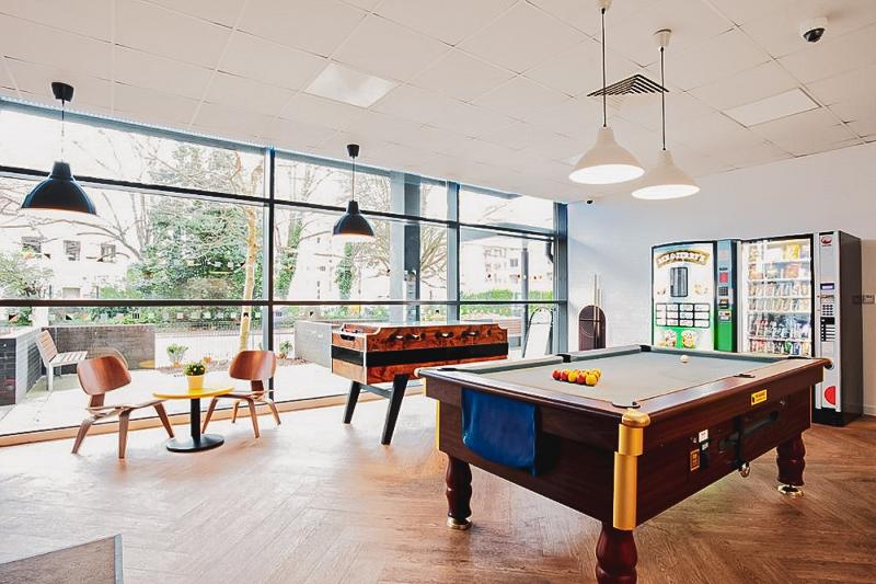 Al soggiorno linguistico inglese estivo a Bournemouth c'è una stanza da gioco luminosa con un tavolo da biliardo e uno da biliardino