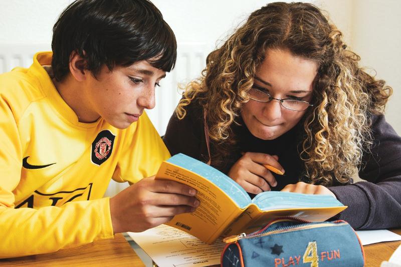 Al soggiorno linguistico inglese estivo a Bournemouth ci sono due ragazzi che stanno leggendo un libro molto attentamente 