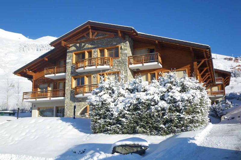 una baita di montagna innevata immersa nel panorama montano