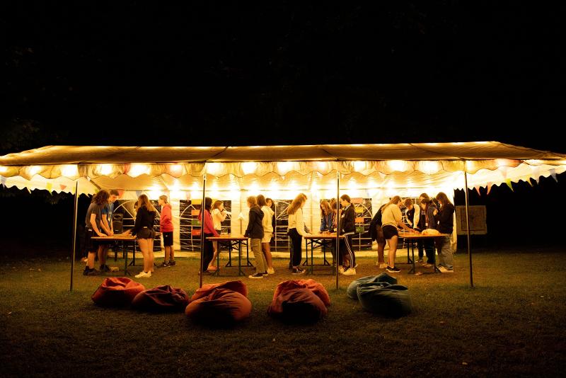 Al campo estivo inglese a Valbonella ci sono dei ragazzi che giocano a biliardino di sera sotto una tenda