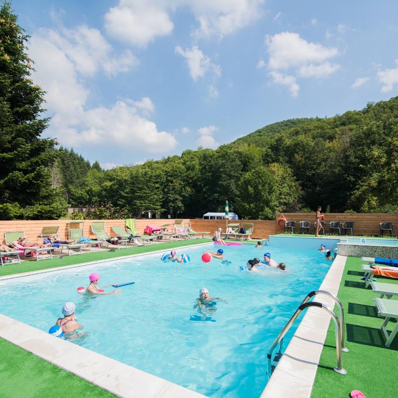 Alla vacanza studio inglese in Italia dei ragazzi giocano a palla in piscina