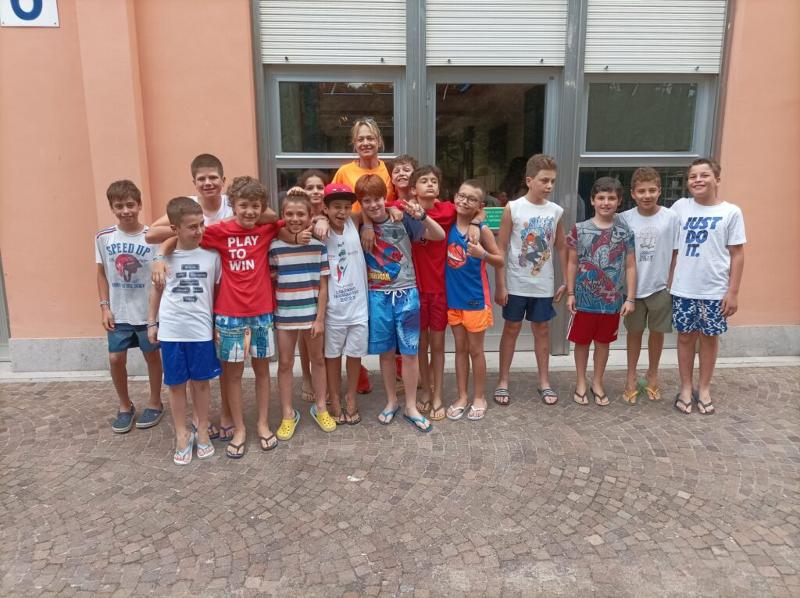 Al campo estivo di basket e minibasket a Lignano Sabbiadoro i bambini si abbracciano facendo una foto con la  animatrice 