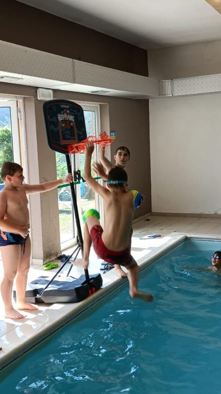 Al campo estivo basket e minibasket a Ligonchio c'è un bambino che sta giocando in piscina facendo canestro 