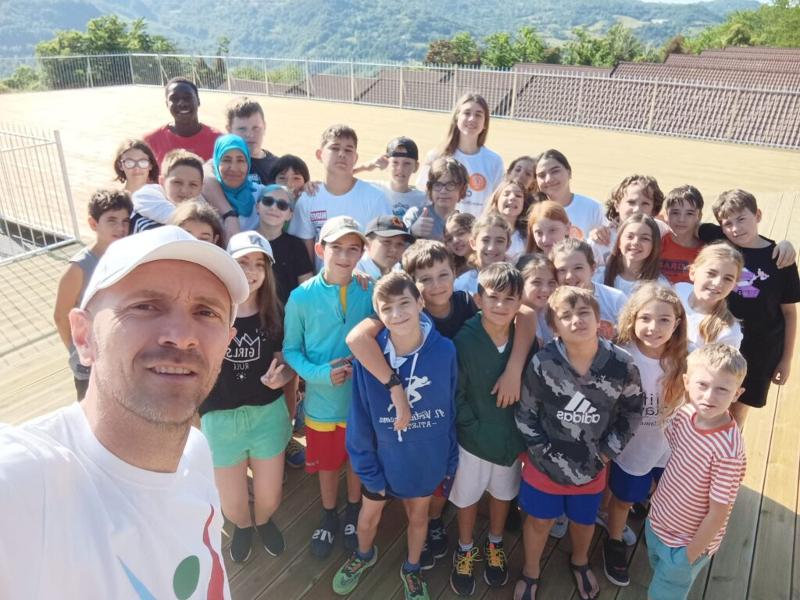 Al campo estivo basket e minibasket a Ligonchio ci sono tanti bambini e bambini che stanno facendo la foto con l'animatore