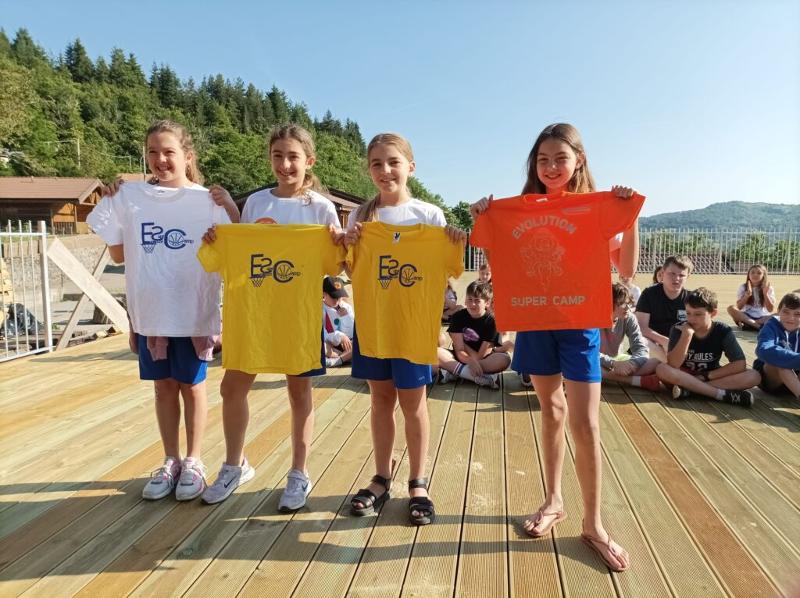 Al campo estivo basket e minibasket a Ligonchio ci sono quattro bambine che fanno vedere le loro magliette personalizzate del campo