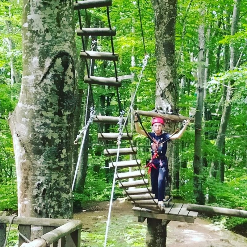 Al campo estivo multisport e minibasket a Ligonchio c'è una bambina che sta affrontando un percorso di arrampicata al parco avventura 