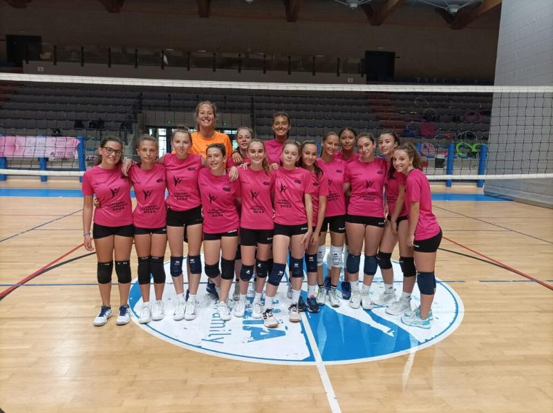 Al campo estivo pallavolo femminile a Lignano Sabbiadoro ci sono delle ragazze riuntite in gruppo per fare una foto con le loro allenatrici 