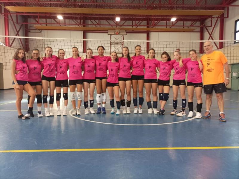 Al campo estivo pallavolo femminile a Lignano Sabbiadoro il gruppo delle partecipanti è schiearto in campo insieme al loro allenatore 