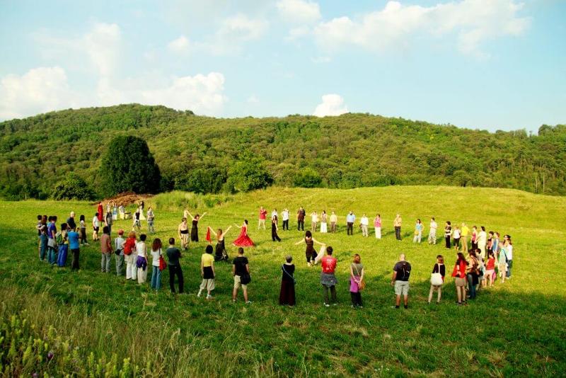 I partecipanti del viaggio organizzato Bologna sono in cerchio sui prati verdi dei colli della città