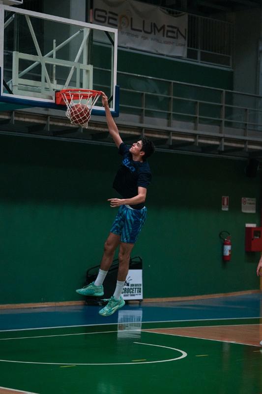 Al campo estivo di basket un ragazzo sta facendo una schiacciata 