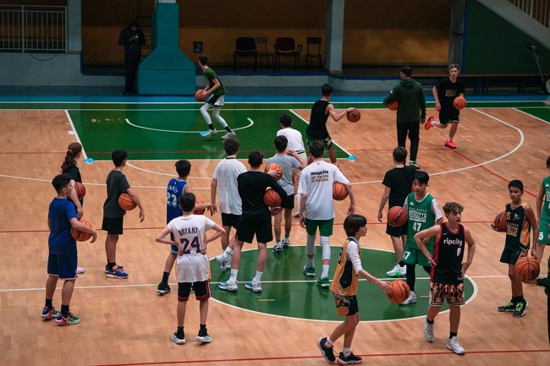 Al campo estivo di basket i ragazzi stanno facendo un allenamento nel palazzetto interno 