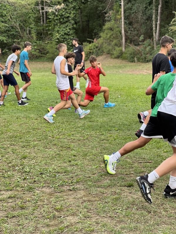 Al campo estivo di basket i ragazzi si stanno allenando all'esterno facendo ginnastica