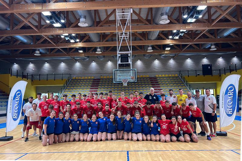 Al campo estivo di basket i ragazzi stanno facendo una foto di gruppo in palestra 