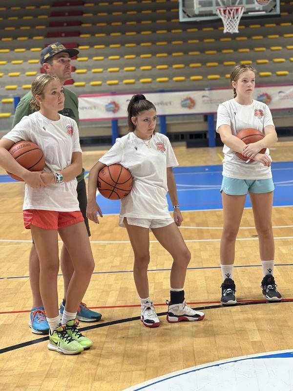 Al campo estivo di basket le ragazze stanno osservando come si svolge l'esercizio 