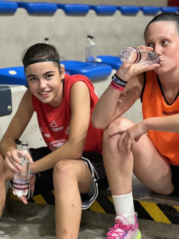 Al campo estivo di basket due ragazze si stanno dissetando durante l'abbonamento
