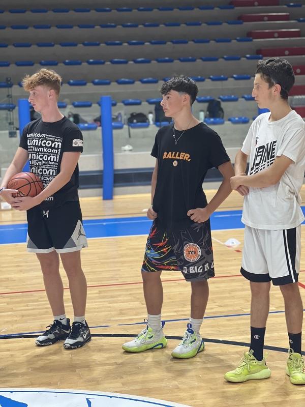 Al campo estivo di basket i partecipanti stanno osservando l'esecuzione di un esercizio 