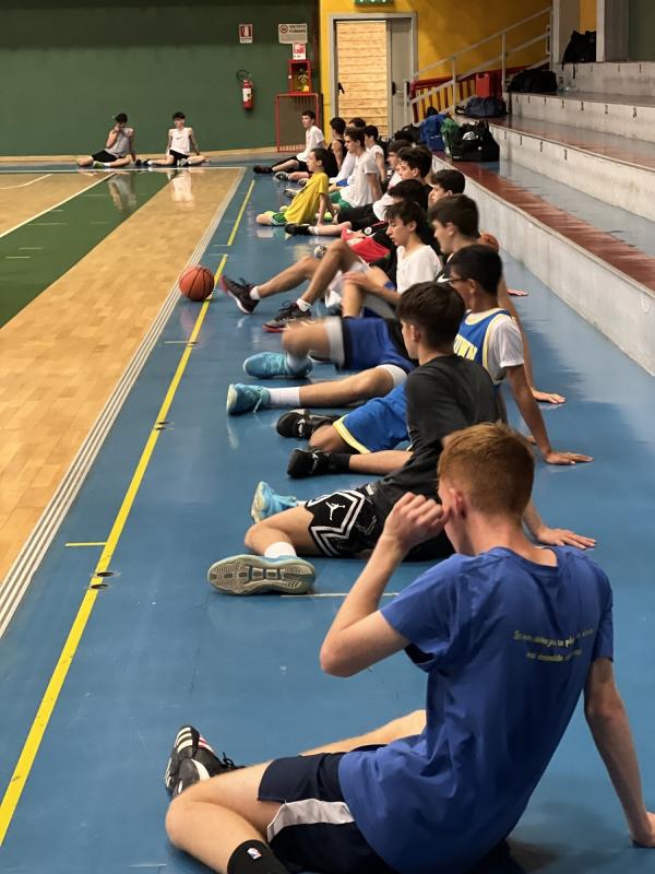 Al campo estivo di basket i partecipanti stanno facendo ginnastica 