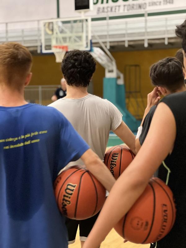 Al campo estivo di basket i ragazzi stanno facendo esercizi per migliorare la loro tecnica 