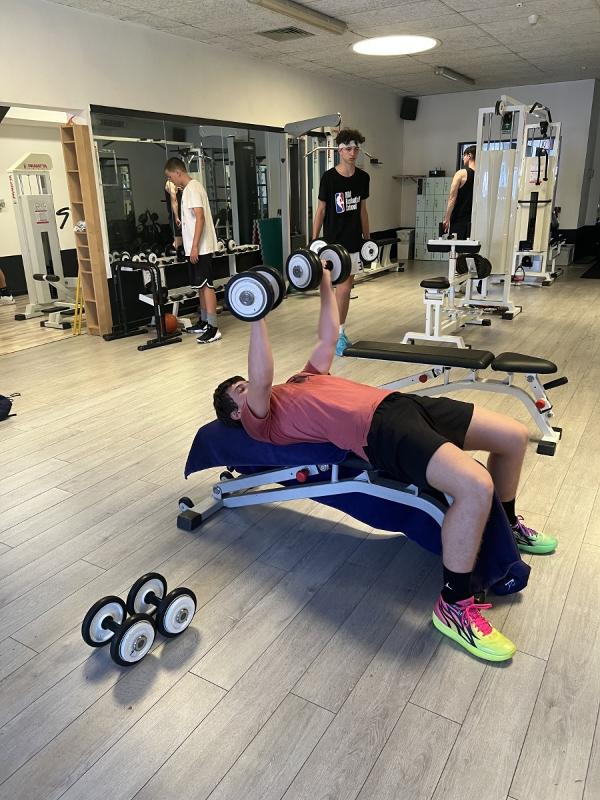 Al campo estivo di basket un ragazzo si sta allenando in palestra 