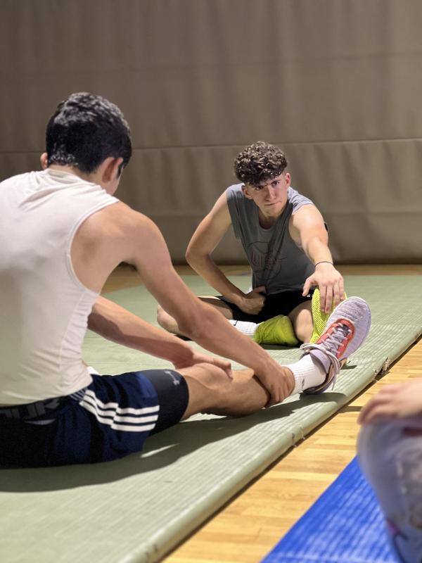 Al campo estivo di basket i partecipanti stanno facendo stretching 