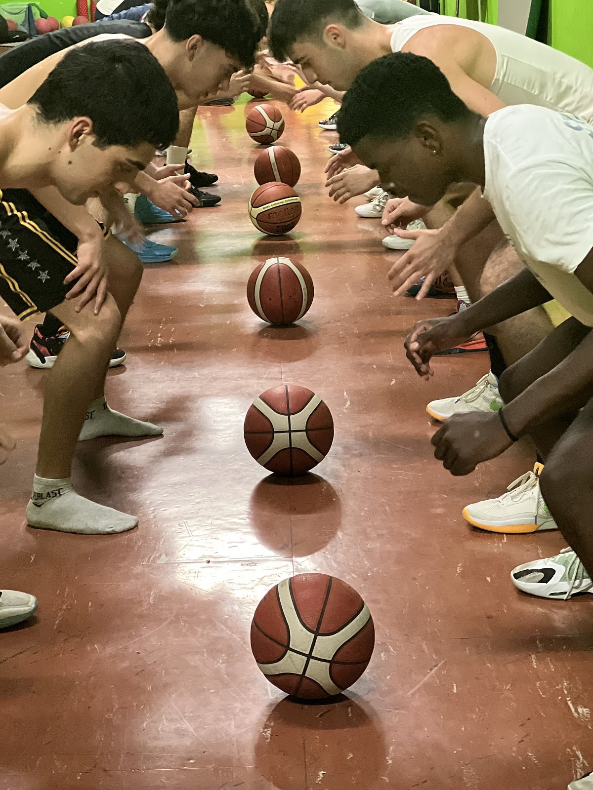 Esercizi tecnici al campo invernale di basket Al campo invernale di basket i partecipanti stanno facendo un esercizio di tecnica