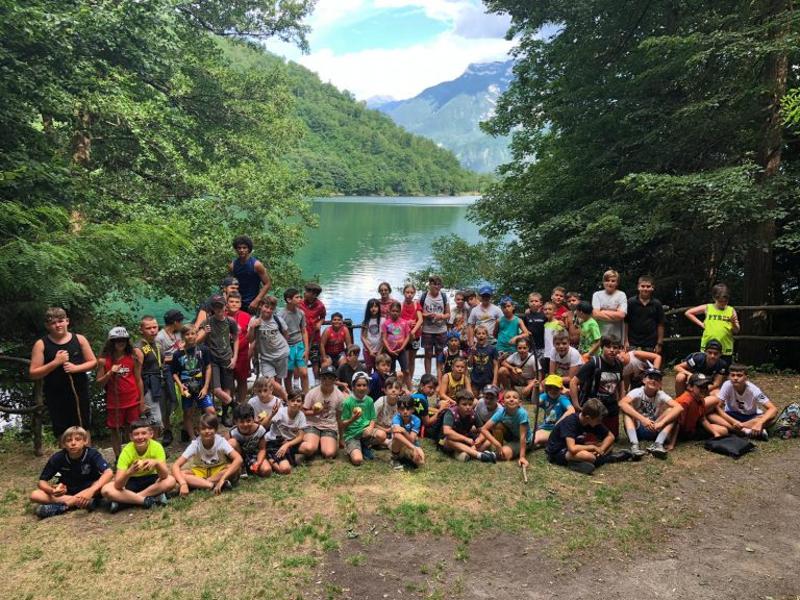 Al campo estivo multisport sul Lago di Levico i ragazzi si fanno una foto di gruppo davanti al lago tutti insieme 