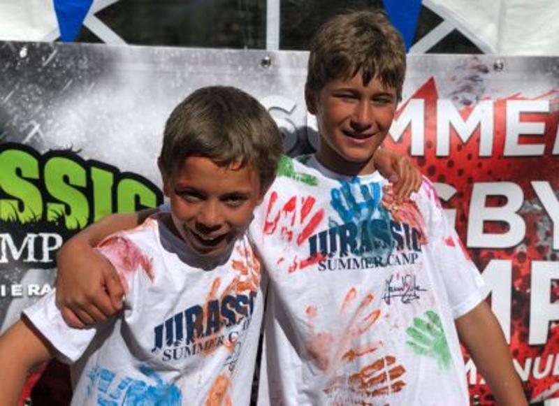 Al campo estivo multisport sul Lago di Levico ci sono due bambini che sorridono e si fanno una foto entrambi con le magliette del campo 
