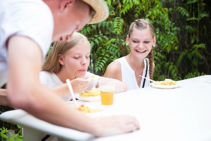 Al soggiorno linguistico spagnolo i ragazzi sono seduti al tavolo e stanno mangiando 