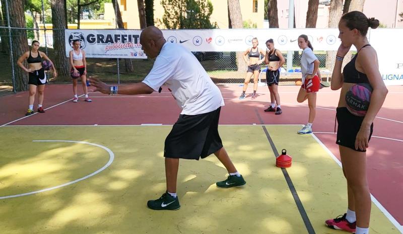 Il coach spiega alle ragazze le regole dello sport al campo estivo All Star basket a Lignano Sabbiadoro