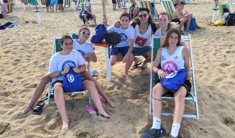 Ragazzi siedono su delle sdraio in spiaggia e sorridono campo estivo All Star basket a Lignano Sabbiadoro