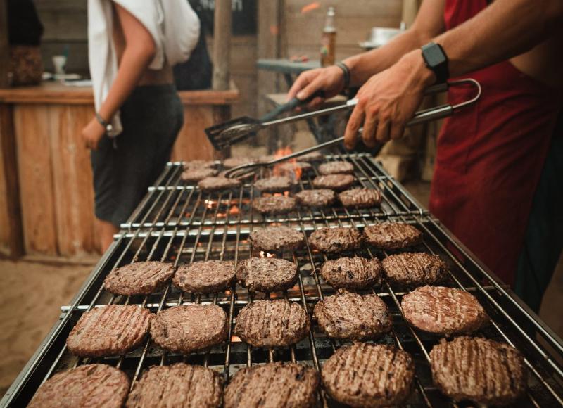 Griglia con molti hamburger al campo estivo internazionale surf Vieux Boucau 