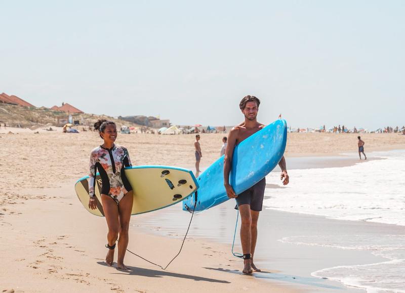 Due ragazzi camminano in spiaggia con le tavole da surf al campo estivo internazionale surf Vieux Boucau