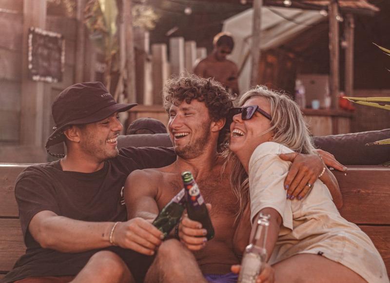 Tre ragazzi sorridono e bevono al campo estivo internazionale surf Vieux Boucau