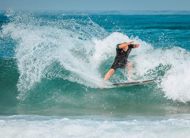 Un uomo surfa tra le onde al campo estivo internazionale surf Vieux Boucau