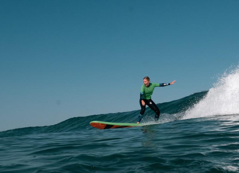 Una ragazza sta sulla tavola da surf al campo estivo internazionale surf Vieux Boucau