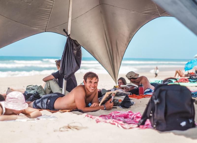 Al campo estivo internazionale surf Vieux Boucau dei ragazzi si rilassano in spiaggia sotto una tenda