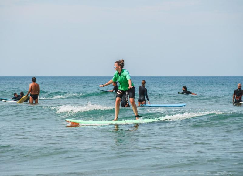 Al campo estivo internazionale surf Vieux Boucau una ragazza si allena a surfare in equilibrio 