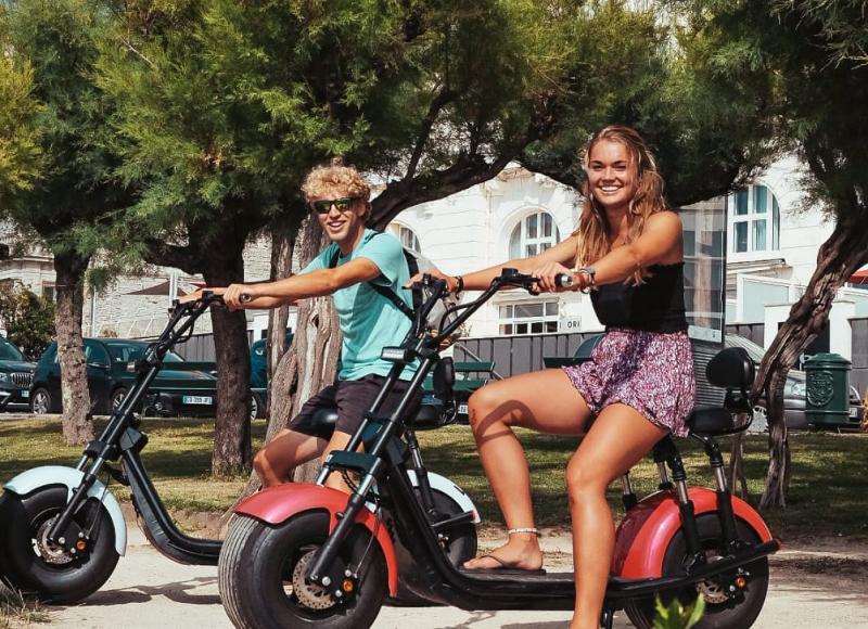 Al campo estivo internazionale surf Vieux Boucau i ragazzi si divertono su delle moto elettriche
