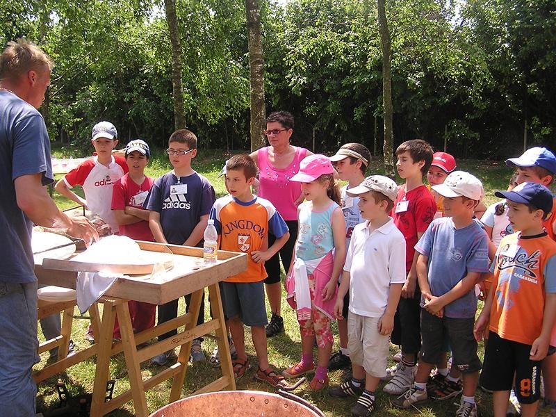 Al campo estivo naturalistico e di equitazione a Vivaro ci sono dei bambini che stanno guardando come si fa il formaggio 
