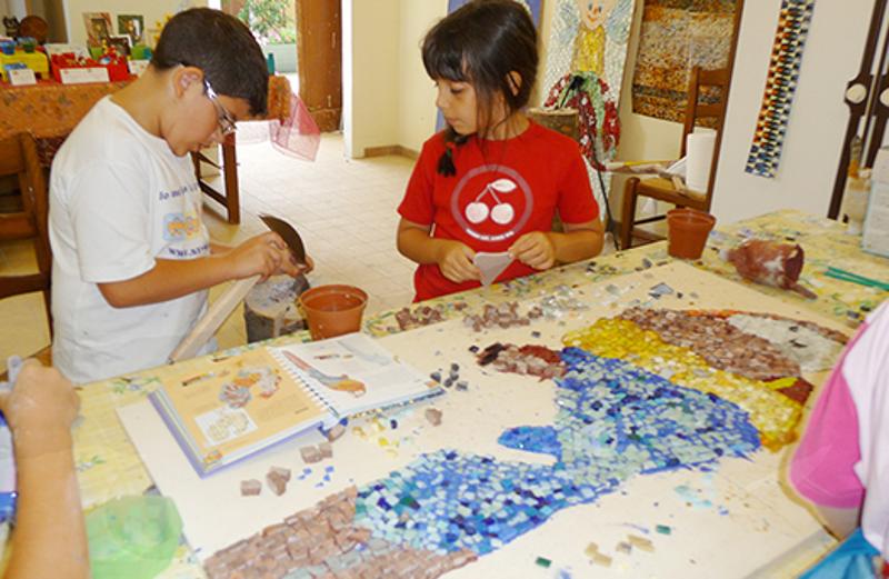 Al campo estivo naturalistico e di equitazione a Vivaro due bambini stanno giocando sul tavolo insieme