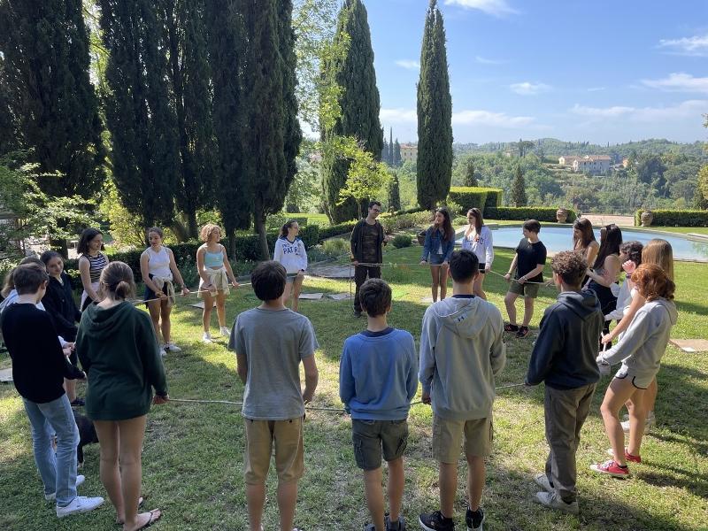 I partecipanti delle vacanze per giovani Toscana sono riuniti in cerchio per delle attività di team building